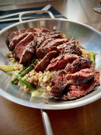 Ribeye Steak with Creamed Farro and Charred Garlic Scapes. Photo courtesy Aster & Rose