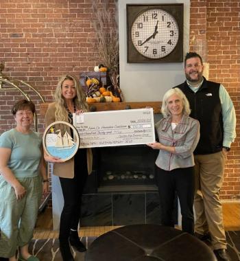 (L to R) Amy Rollins, Jody Landrith, and Erick Anderson, volunteers for Christmas By the Sea, present a check in the amount of $930 to Stephanie Smith (second from right) of the Knox County Homeless Coalition Board of Directors. The donation was made possible by Christmas By the Sea ornament sales last December. (Photo courtesy Camden Area Business Group)