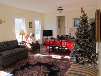 The refurbished room with donated furniture and a Christmas tree in 2022. Kathy Onofrio, is in the background. Photo by Kay Stephens
