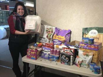 Front desk associate Kelsey Pryne with the items going towards the Pope Memorial Humane Society, Dec. 16. (Photo courtesy Thomaston Place Auction Gallery)