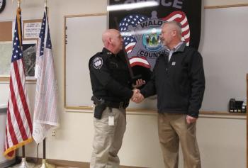 Sheriff Trundy presenting outgoing, former Sheriff Jeffrey Trafton with a retired badge as a token of appreciation from the Sheriff’s Office. (photo by Erica Thoms)