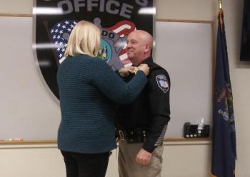 Lorraine Trundy pins her husband, freshly sworn in Sheriff Jason Trundy. (photo by Erica Thoms)