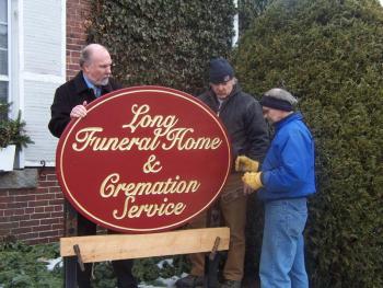 The installation of the Long Funeral Home sign with John Long, John Long, Walt Simmons, owner of Ducktrap Woodworking and who made the sign, and Bill Clement. (Photo courtesy Long Funeral Home)
