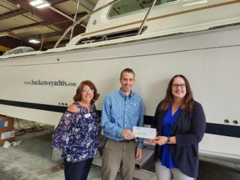 Jason Constantine, president of Back Cove Yachts, presents a check for Rockland Rotary's Inclusive Playground Project to club president, Tena Wallace (L) and Rotarian Susan Page (R) for $2,500.