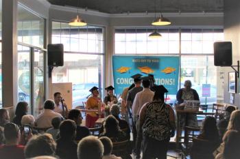 Graduates march through the crowd onto the stage at Rock City Café to music provided by cellist, Robin Lane.