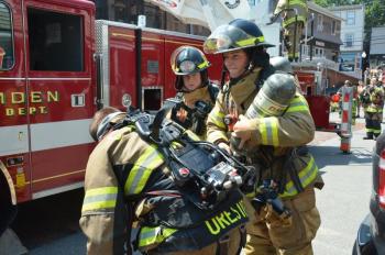 Changing air tanks on firefighters entering the smoke-filled building. (Photo by Lynda Clancy)
