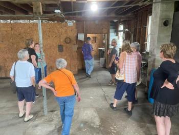 MFT’s Adam Bishop (back, right) leads a tour of the buildings on the property with potential for storage and other uses.