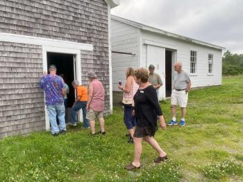 Visitors take a tour of the buildings on the property with potential for storage and other uses.