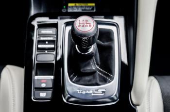 A rare sight now: a manual shift lever for a 6-speed gearbox. This one is stubby, perfectly positioned and operates with—pardon the cliché—the precision of a rifle bolt. Alongside are the electronic e-brake switch and the drive mode selector.