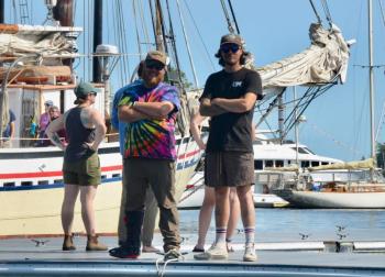 Camden staff members Josh Johnson and Adam Jipson helps out as the schooners move in Friday afternoon. (Photo by Lynda Clancy)