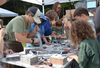 Children enthusiastically make use of stone-cutting tools at an artisan table set up by the Maine Stone Guild. (Photos by Lynda Clancy)