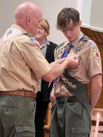 Eagle Scout Jim Murphy pins the Eagle medal on Josiah Hays as Josiah's mother Beverly looks on. (Photo courtesy Chuck Mahaleris)
