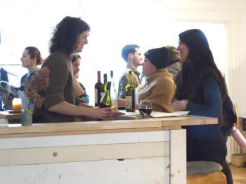 Waldoboro Inn owner, Ida Wine Bar server, and internationally renown fashion designer Alexa Stark serves Waldoboro knitter Zoe Lindquist during the Holiday Market on Dec. 2. (Sarah Masters photo)