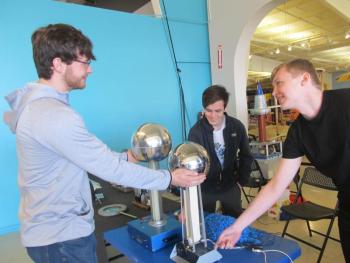 University of Maine undergrad students in the College of Engineering & Physics Program demonstrate how an electrostatic generator conducts “hair raising” static electricity. Photo by Kay Stephens