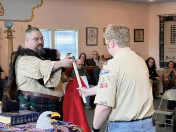 Jeremiah Loft, a member of the staff of the Bomazeen Bushcraft program, presented James with a candle lantern and tomahawk which are given to all Eagles who also completed the Bushcraft program. James' Bushcraft name was Wild Rover. (Photo courtesy Chuck Mahaleris)
