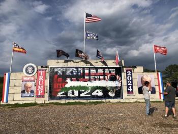 In Waldoboro, Anthony Lash (left) talks with neighbors about the recent vandalization of the large monument to President Trump. Sometime during the final week of May, the banner stating TRUMP 2024 was painted with an image which appears to be similar to the Palestinian Flag. (Sarah Masters photo)
