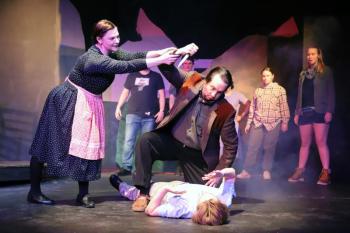 Meredith (Maggie Machaiek) urges Dr. Parker (Andrew Lipman) to show compassion to Bat Boy (Miles Mailloux, supine) despite the townspeople's (background, l-r: Dakota Wing, Malaya Moore, Ada Curry, Katey Stearns) pleas to kill him. (Photo courtesy Belfast Maskers)
