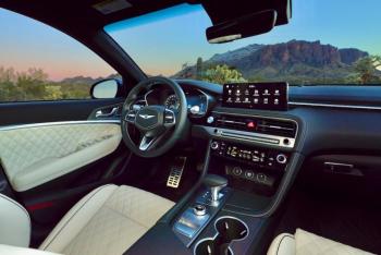This is the Nappa leather and microsuede interior of the Sport Prestige upgrade as applied to the G70 3.3T. Aft of the gear-selector lever is the drive mode-selector knob and, below that, right where it should be, the e-brake switch.