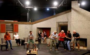 The cast of "Playboy of the Western World" (l-r: Greta Brown, Emily
LeBlanc McConnell, Tyler Johnstone, Ember Hoffman, Eden Hoffman, Isla Hughes, Mark Durbin, Tom Maycock, Tyson Hoffman, and Greg Marsanskis) rehearse on the Basil Burwell Community Theater stage. Set design: John Bielenberg. (Photo by Gwyneth Sauvage)