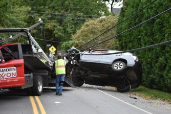 A car is loaded onto a wrecker after toppling a utility pole on Washington Street. (Photo by Sarah Thompson)