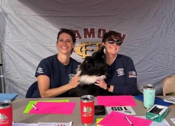 Jen Farley and Jodi Hanson, with Hazel, register runners at the annual Camden Fire Dept. Windjammer 5K. (Photo by Lynda Clancy)