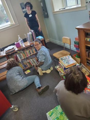 A group of volunteers rearranges the children's area of the Thomaston Public Library during 2023's Together for Thomaston Event. (Photo by Kendray Rodriguez)