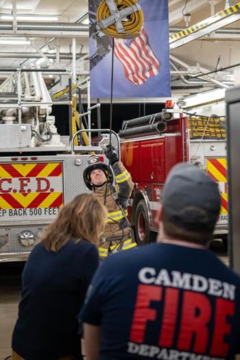 Firefighter Dylan Cautela hoists hose. (Photo by Tim 