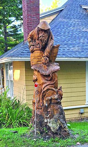 This detailed wooden carving sits at the corner of one property, leading many to slow slightly to take in the intricacies of the art piece.  (photo by Erica Thoms)