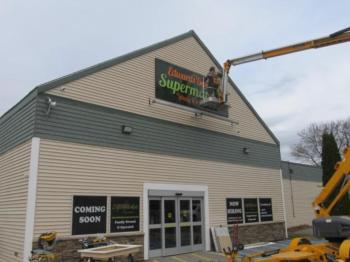 Last touches on the sign for the new Edwards Brothers Supermarket in Searsport. Photo by Kay Stephens
