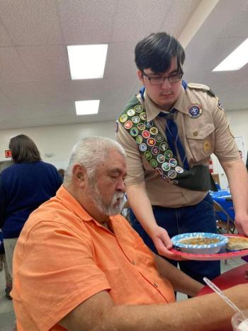 At the Veteran's Appreciation Beef Stew Dinner put on by the Warren Historical Society, veteran Danny Swindler is served lunch by his grandson Star Scout Logan Bailey, who is a member of Troop 254 Warren. (Photo courtesy Chuck Mahaleris)