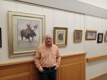 Artist Peter Giustra stands with some of his works, now on display at MaineHealth Pen Bay Hospital. (Photo courtesy MaineHealth)