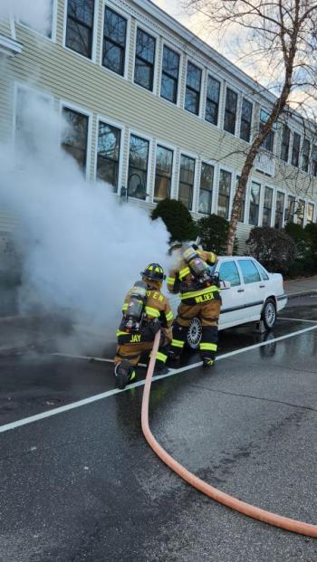 Camden firefighters tackle the car engine fire with water. (Photo courtesy Camden Fire Dept.) Dousing the car fire
