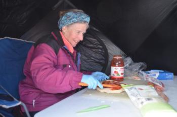 Ragged Mountain Ski Patroller Jada Beardsley makes pizzas for the patrol fundraiser out of the wind inside a small tent on Hosmer Pond. (Photo by Lynda Clancy) (Photo by Lynda Clancy)