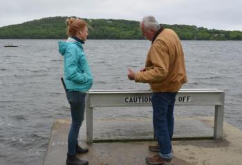 In May 2023, Rockport resident and fisherman Kenneth Dodge and Camden resident Alison McKellar were at the small gate near the foot of Chickawaukie Pond, where the water feeds into Meadow Brook at Johnson Memorial Park, in Rockland. The gate had gotten stuck closed at a crucial time of year when the alewives were swimming up from the ocean to freshwater in order to spawn.
Dodge caught wind of that news after his cousin learned that the small fish were unable to make their last hurdle into the lake, and were crowding each other at the gate, some dying.
Children were spotted trying to help the fish, grabbing buckets, filling them with the alewives and transporting them from the brook back over to the 352-acre lake.
“The fish have to get up that river to spawn,” said Dodge, who has been watching the same phenomenon since he was a small boy, 60-plus years ago.
The gate was finally opened with more clearance. (Photo by Lynda Clancy) Alison McKellar and Kenny Dodge
