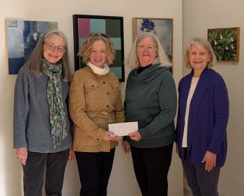 Gallery owners present a check to New Hope Midcoast. L-R: Leslie Moore; Rebekah Parades, Executive Director of New Hope Midcoast; Debbie Mitchell, and Betty Schopmeyer. (Photo courtesy Local Color Gallery)