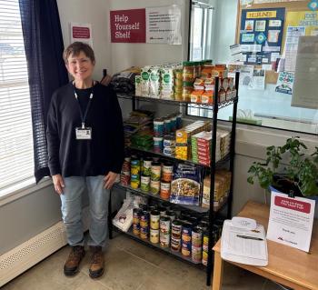 Sharon McVaugh, family peer support partner at Maine Behavioral Health in Rockland, stands with the new Help Yourself Shelf.  McVaugh is also the site champion for MaineHealth Pen Bay Hospital’s newest shelf. (Photo courtesy MaineHealth)