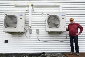 a man standing next to heat pumps