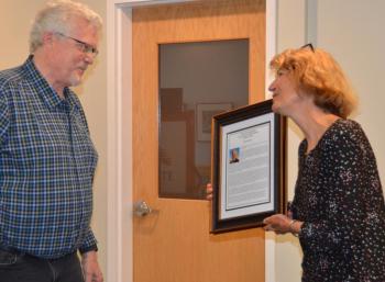 Richard Remsen is surprised by the dedication of the town report presented to him by Rockport Select Board Chair Denise Munger. (Photo by Lynda Clancy) c