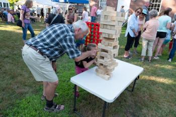 LCHA volunteer Dan Watts assists a youngster with a Jenga tower at last year's "Jailhouse Rock!" event. (Photo courtesy Lincoln County Historical Association)