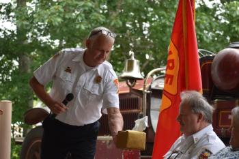 Camden Fire Chief Chris Farley presents the "Chiefly" gift to Keller. (Photo by Sarah Thompson)