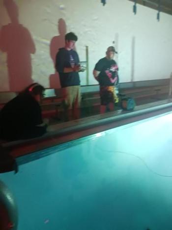 Three people poolside in the dark