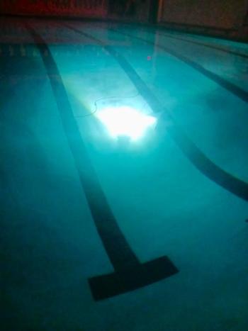 dark room and pool with bright light shining from submerged ROV