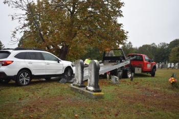 damaged car being pulled onto flatbed truck