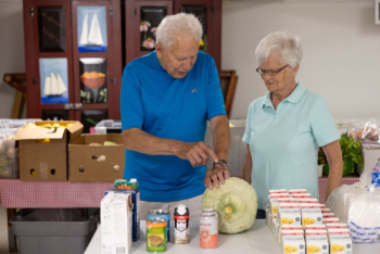Keith Ritchie and Betty Williams chatting in the food pantry.