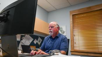 Mike Arsenault sits at his desk.