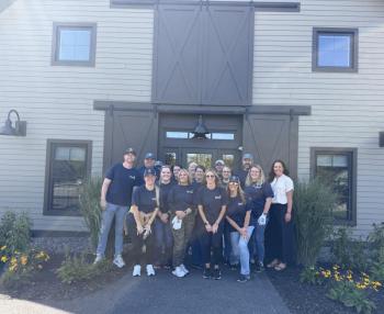 Camden National Bank employees supported the Travis Mills Foundation by stacking wood, cleaning their gymnasium and detailing veteran vehicles during their dedicated Community Well-being Day. (Photo courtesy Camden National Corporation)