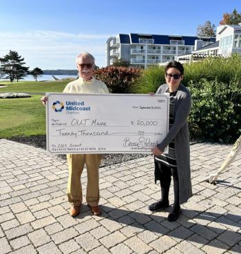 Man and woman pose with gigantic check
