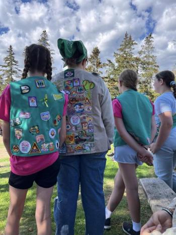 Many badges fill the backs of Girl Scout vests