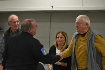 Eric Quatrano shakes hands with Select Board member Peter Lammert as Chris Rector and Kimberly Matthews look on. (Photo by Sarah Thompson)