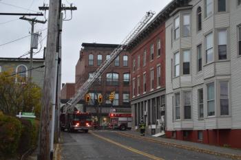 Ladder truck raised into position to reach the roof of a building